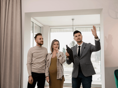 picture showing a pregnant couple as real estate investors checking real estate with a broker